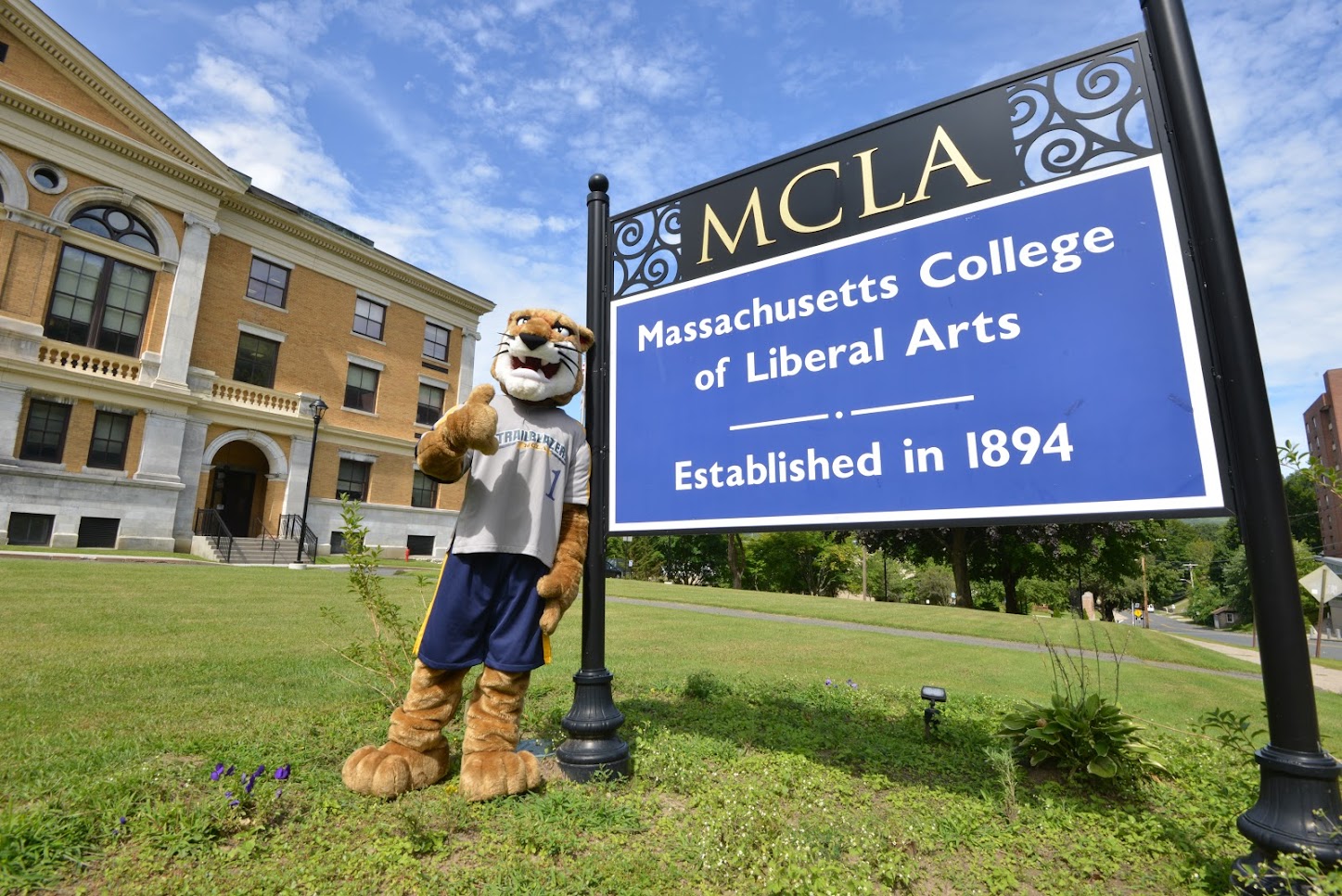 Mascot standing by college sign