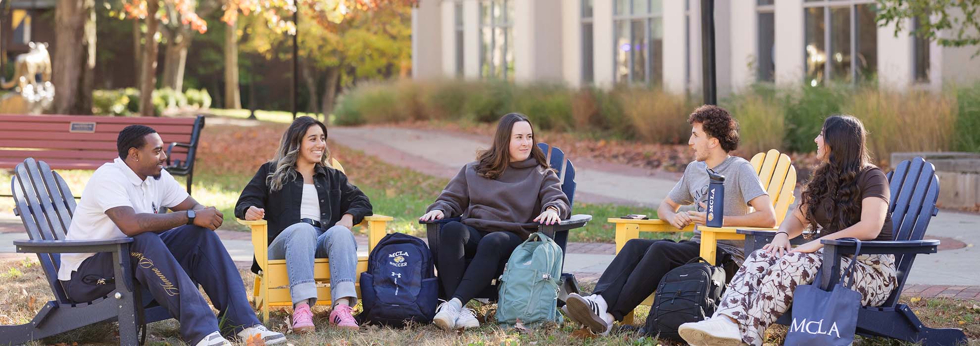 MCLA students sitting outdoors having a friendly discussion